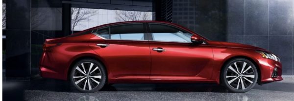 Red 2019 Nissan Altima parked in front of a modern office building.